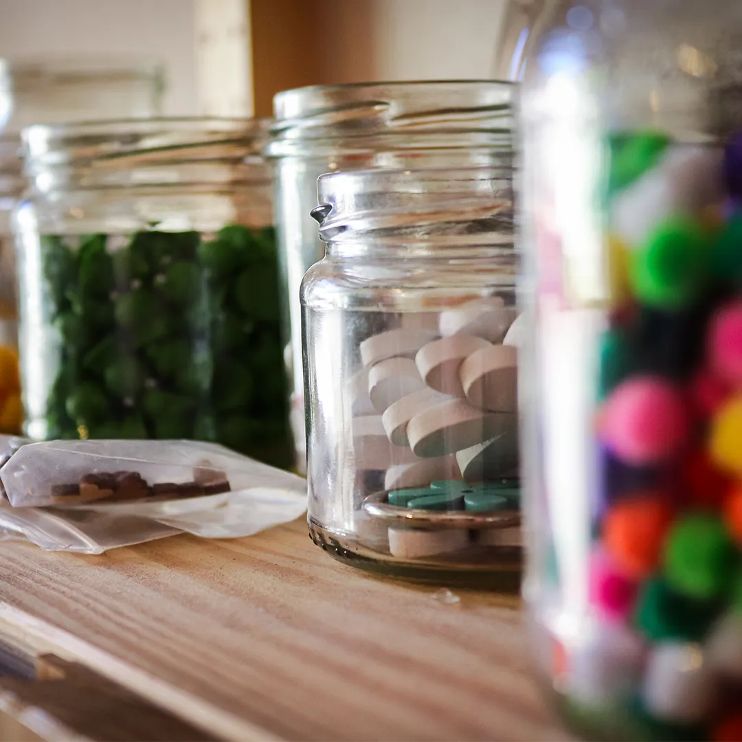 verschiedene offene glaeser mit buntem inhalt zum basteln